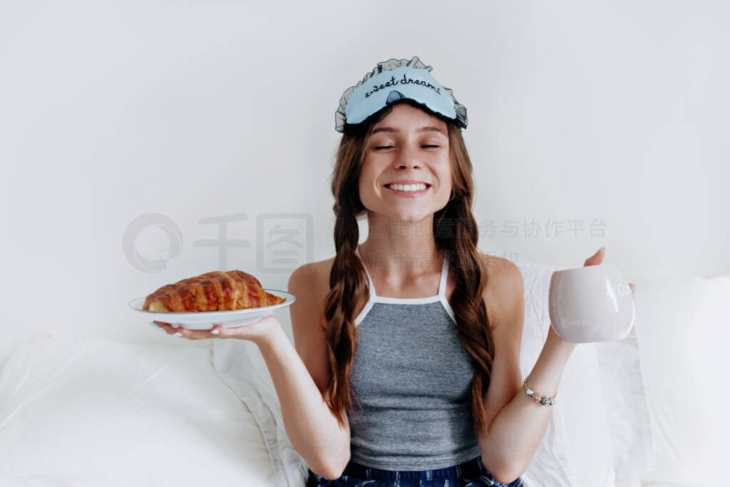 Satisfied girl with pigtails and sleeping mask on the head weari