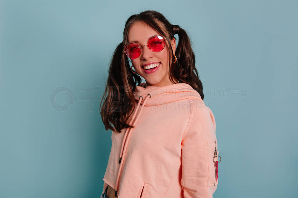 Inspired incredible girl in pink blouse smiling on blue backgrou