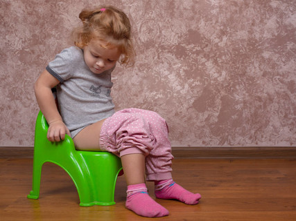 小女孩坐在便盆上,孩子学着上厕所
