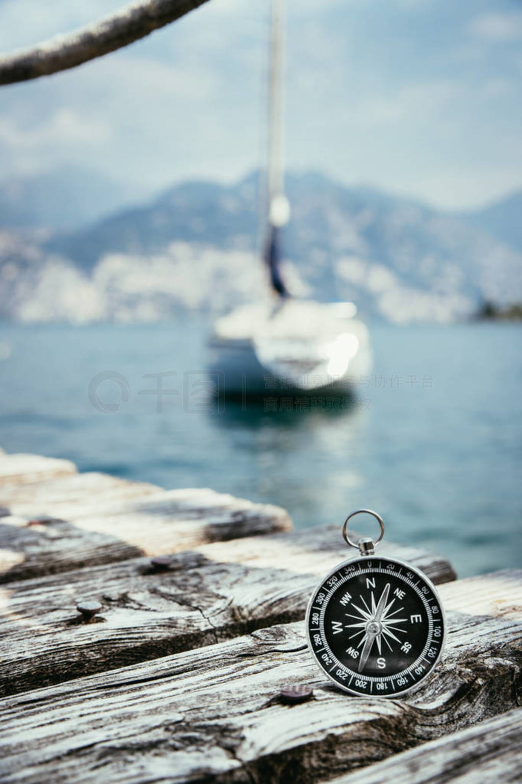 Sailing: nautical compass on wooden dock pier. Sailing boats in