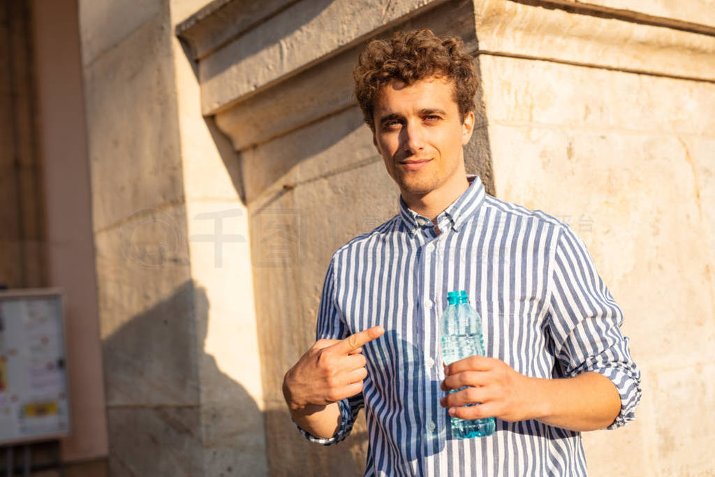 young man drinking water outside