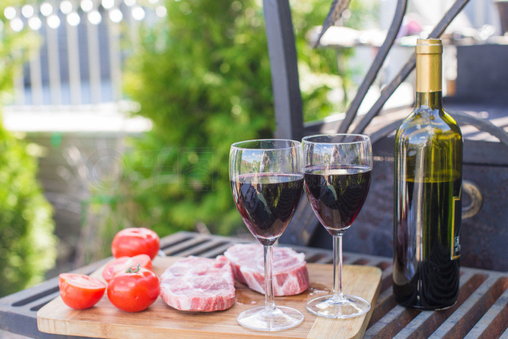 瓶红酒、 牛排和西红柿在野餐户外