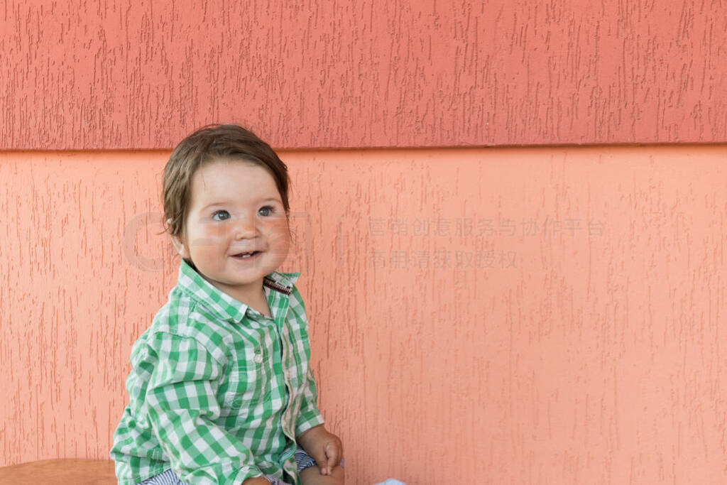 happy baby on a coral background. Head and shoulders portrait of