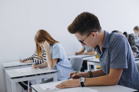 高中学生坐在现代教室里做考试