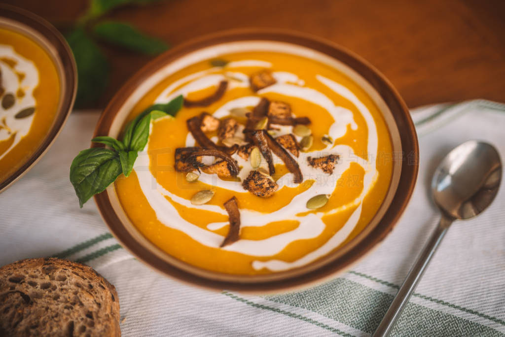 tasty autumn coconut pumpkin cream soup bowl with tofu, caramel