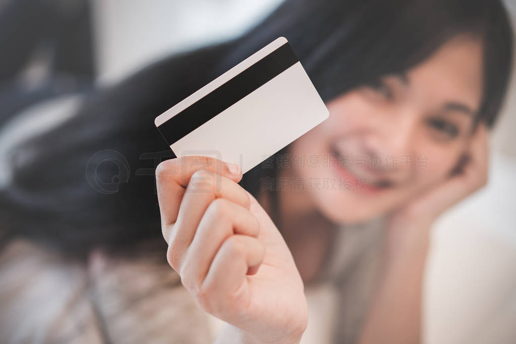 Young woman working on a laptop and uses credit card, bussiness