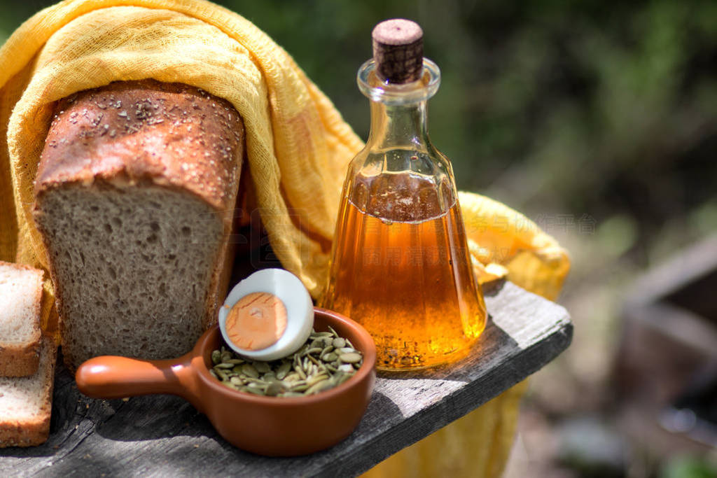 Home-made fresh bread, bottle with sunflower oil, a knife and eg