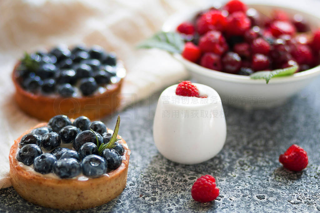 Tartalets with blueberry berries, plate with fresh raspberry and