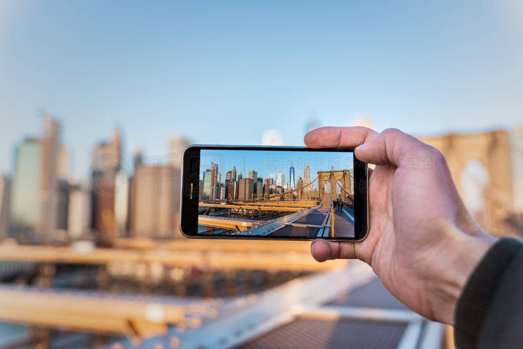 smartphone taking a picture of the skyline of new york from the