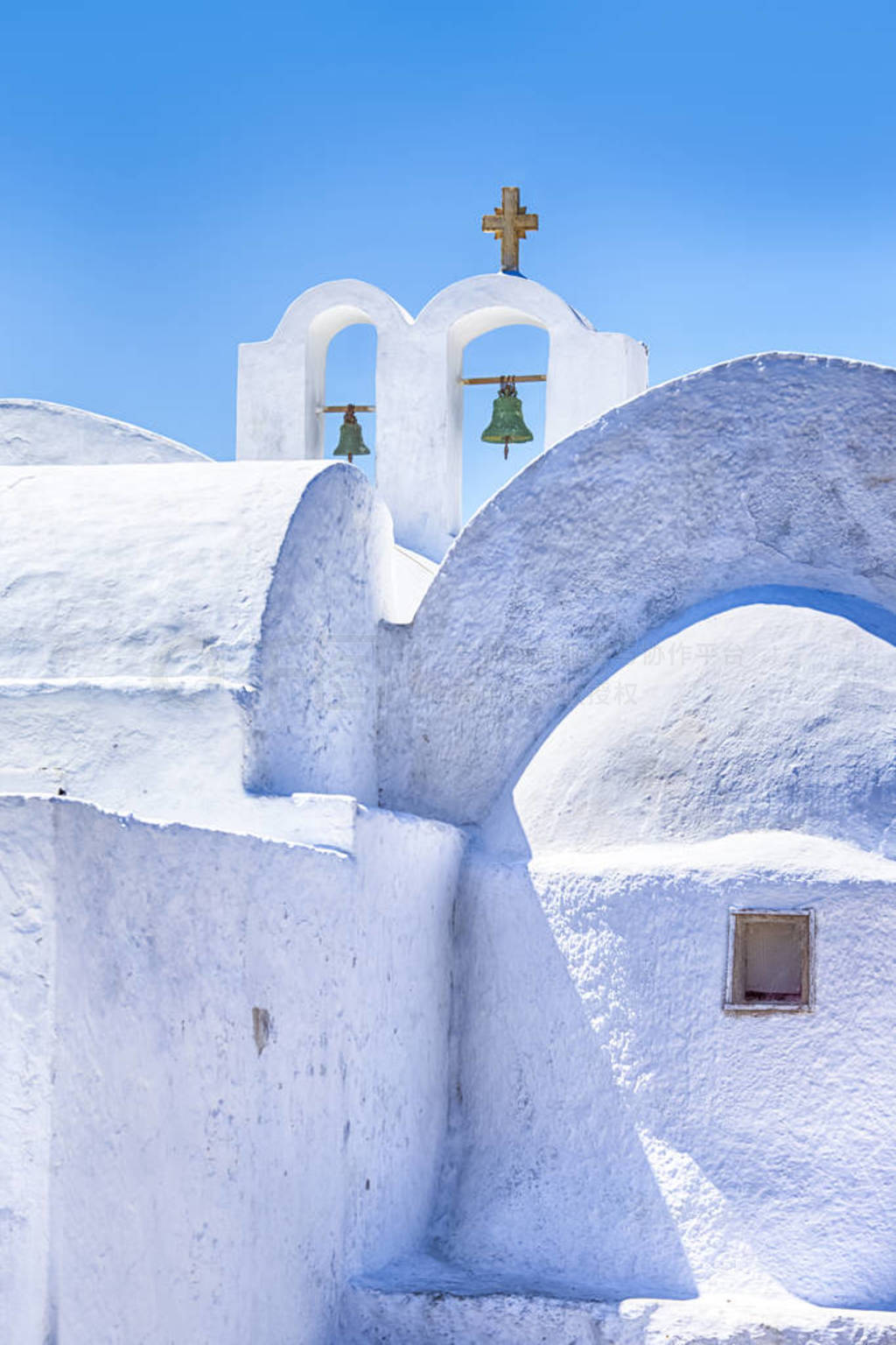 White Walls of Traditional Greek Church With Bells and Cross as