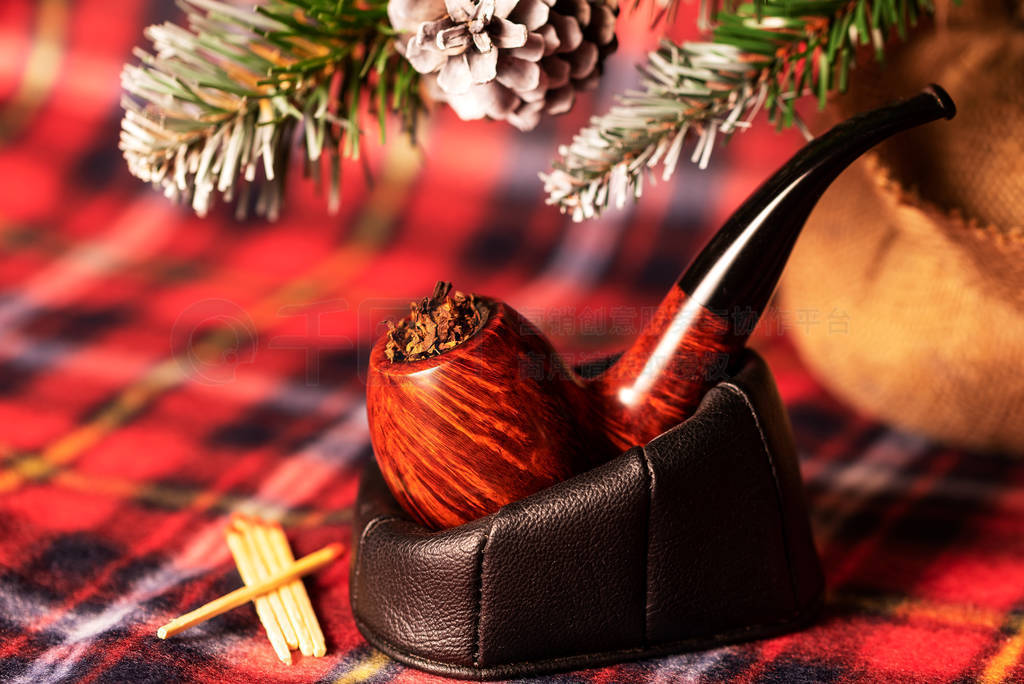 Smoking pipe stuffed with tobacco close-up on the background of