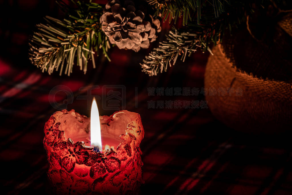 Fragment of a burning candle on a dark background with elements