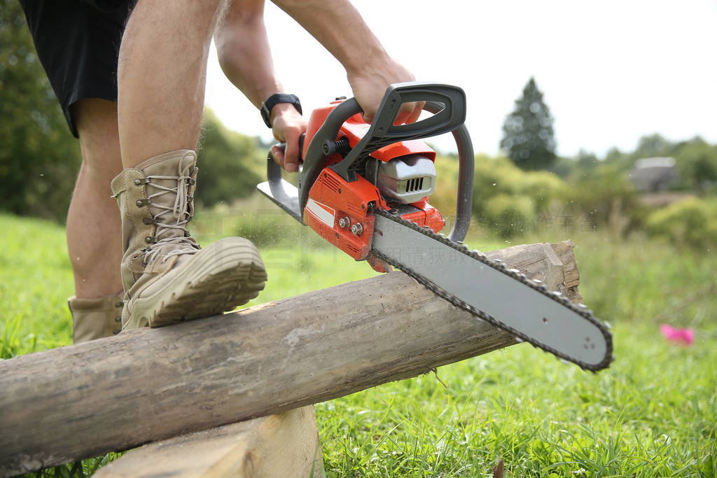 a man saws off a log with a chainsaw