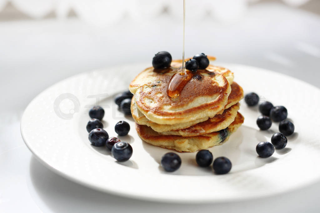 Pancakes with blueberries and maple syrup. Sweet breakfast.