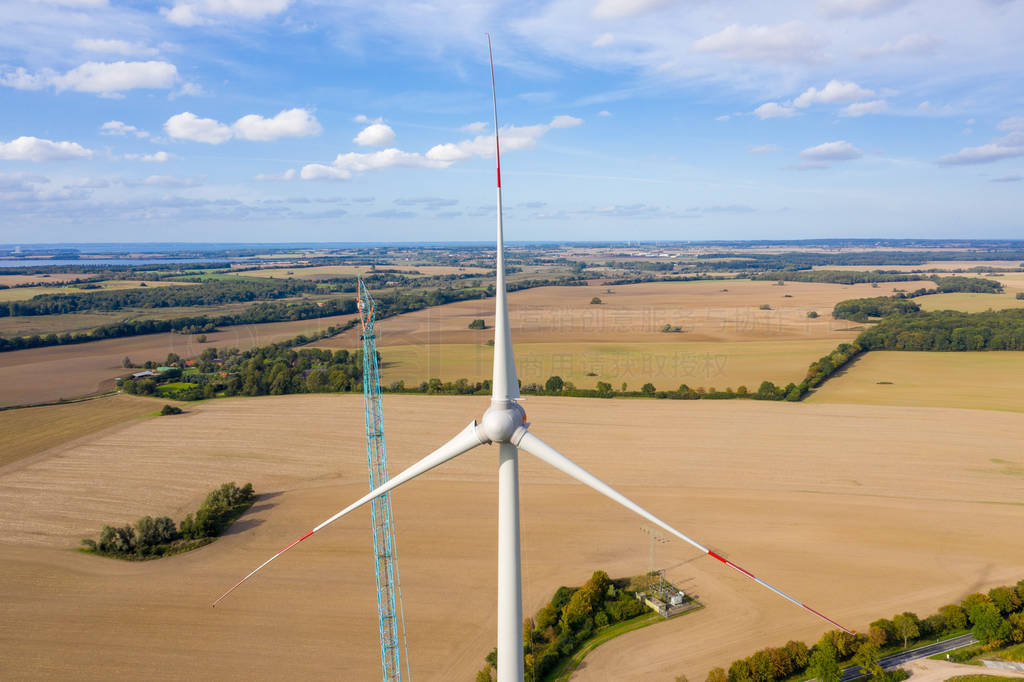 A large wind farm with many wind turbines is built near a small