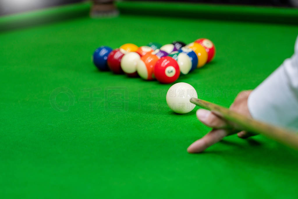 Man's hand and Cue arm playing snooker game or preparing aiming