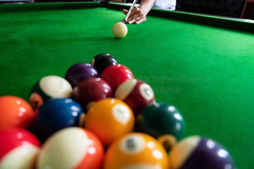 Man's hand and Cue arm playing snooker game or preparing aiming