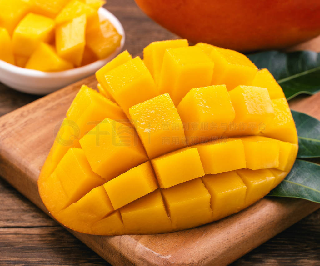 Fresh Mango - Juicy chopped mango cubes on wooden cutting board