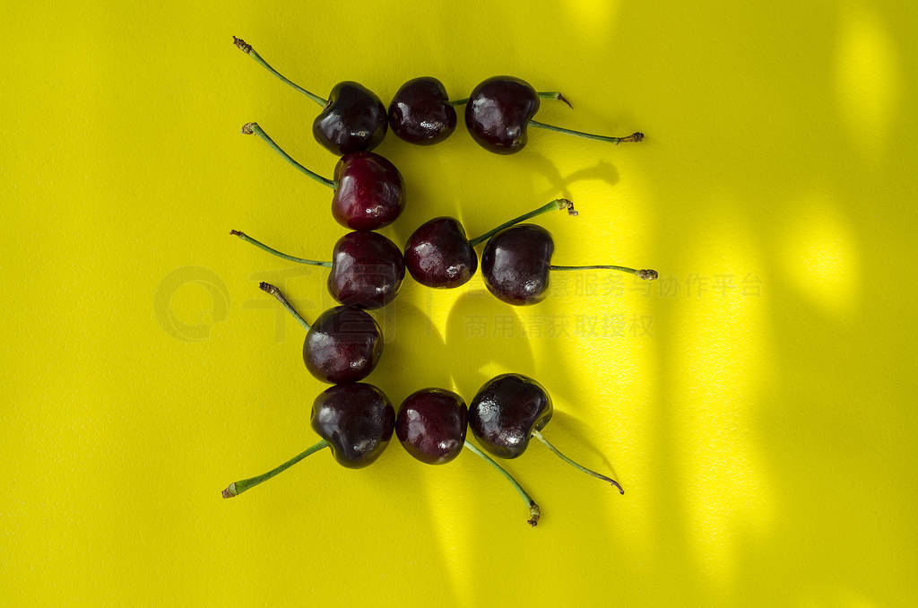 Cherry berries on a bright yellow background in the form of the