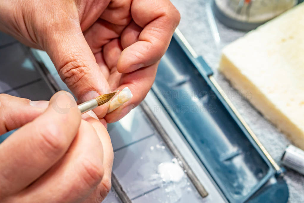 Production of dental veneers. Dental technician at work. Dental