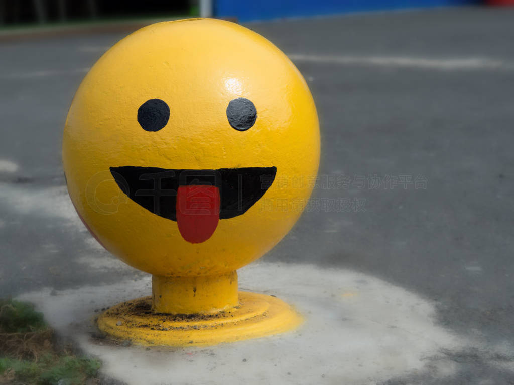 big bright yellow ball-shaped Smiley in the middle of a sidewalk