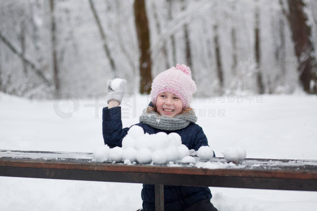 happy child girl playing with snow on snowy winter walk, making