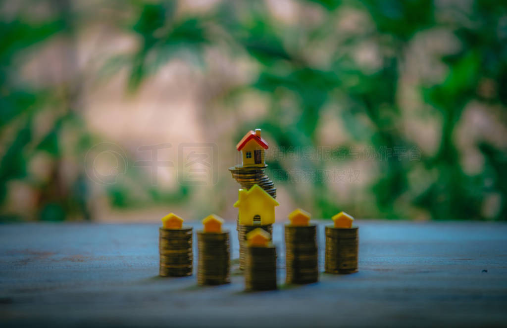 A small house on a pile of coins is used as an asset, financial