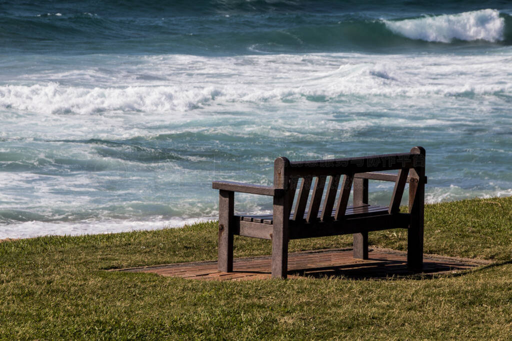 Wooden Bench on Paved Slab Overlooking Rough Sea