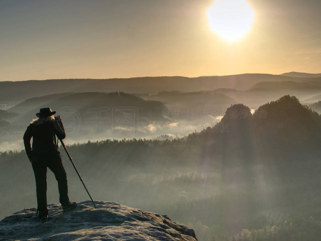 Lady photographer tourist with camera shoots sunrise