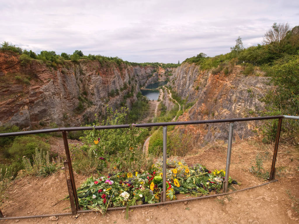 Flowers at handrail above closed mine. Memory to died victims