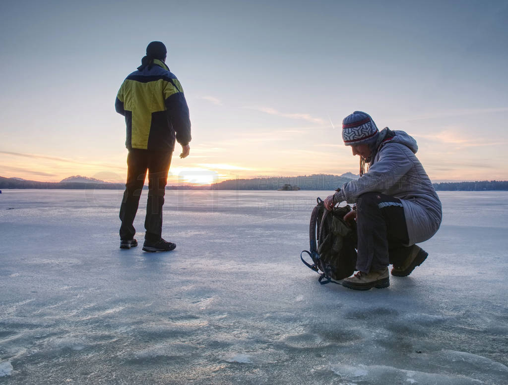 Traveler stay on ice of frozen sea. Woman with backpack