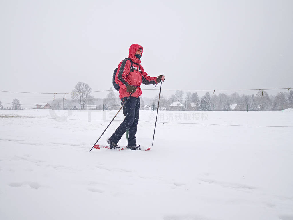 Hiker with snowshoes and technical outdoor clothing