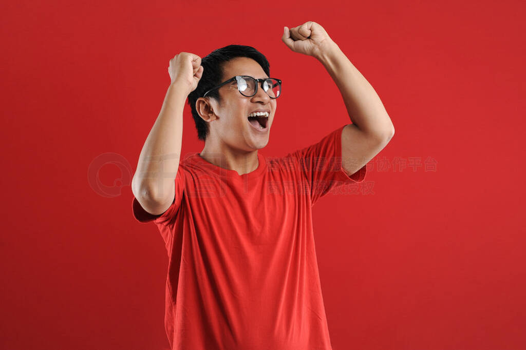 Young asian man happy and excited expressing winning gesture.