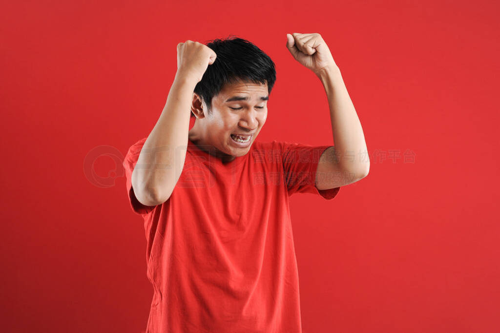 Young asian man happy and excited expressing winning gesture.