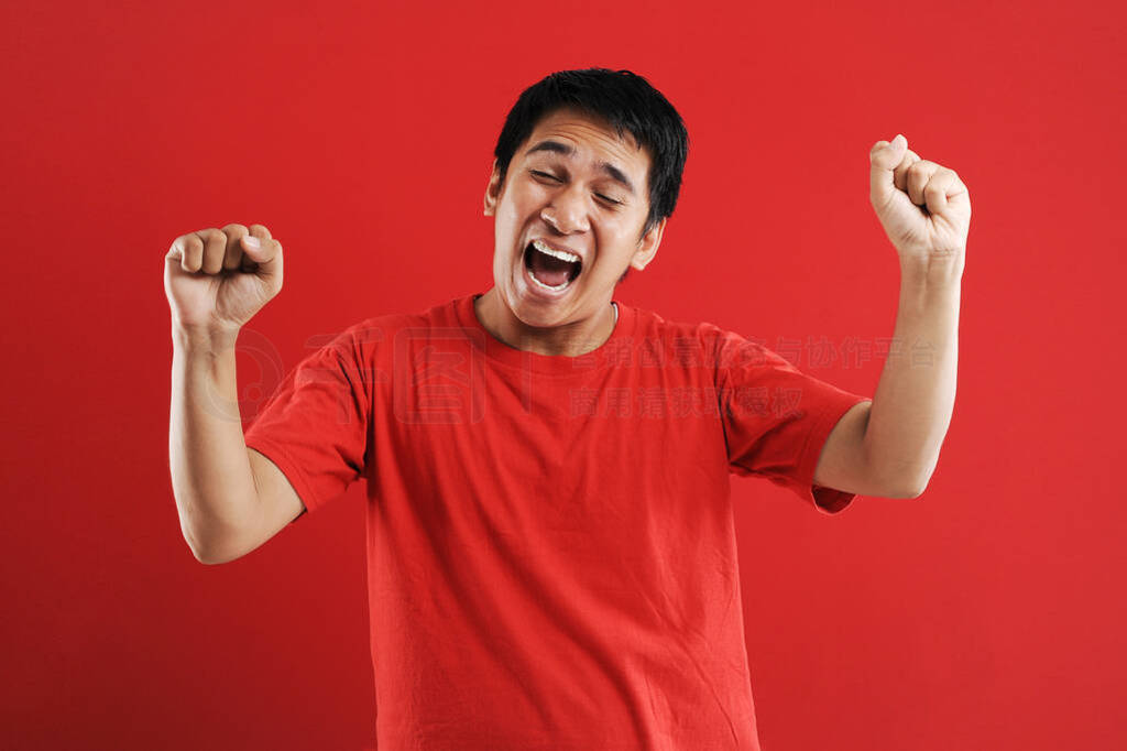 Young asian man happy and excited expressing winning gesture.