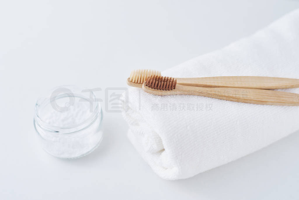 Two wooden bamboo eco friendly toothbrushes on towel and baking