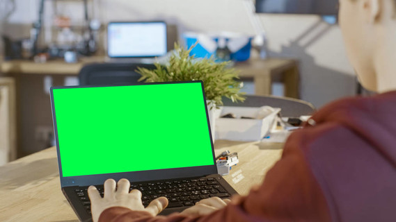 聪明的男孩用笔记本电脑样机绿色在他的电脑屏幕