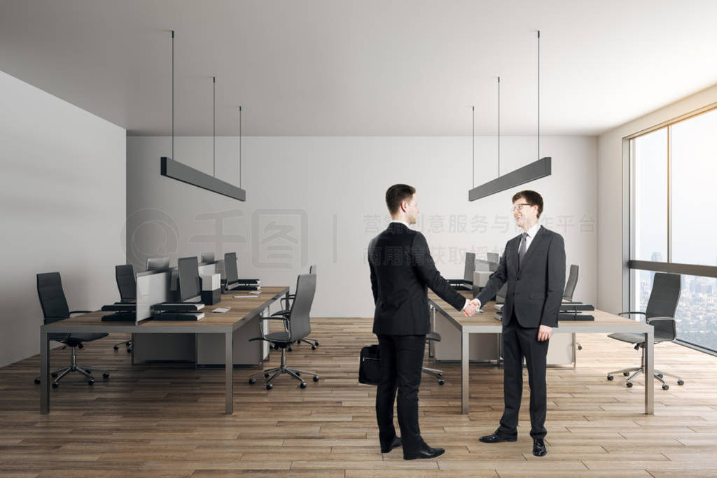 Businessmen shaking hands in office