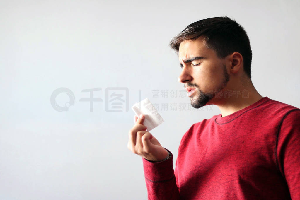 Health and Medicine Concept: Man dressed in red blowing his nose