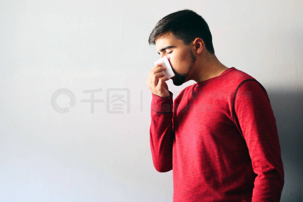 Health and Medicine Concept: Man dressed in red blowing his nose