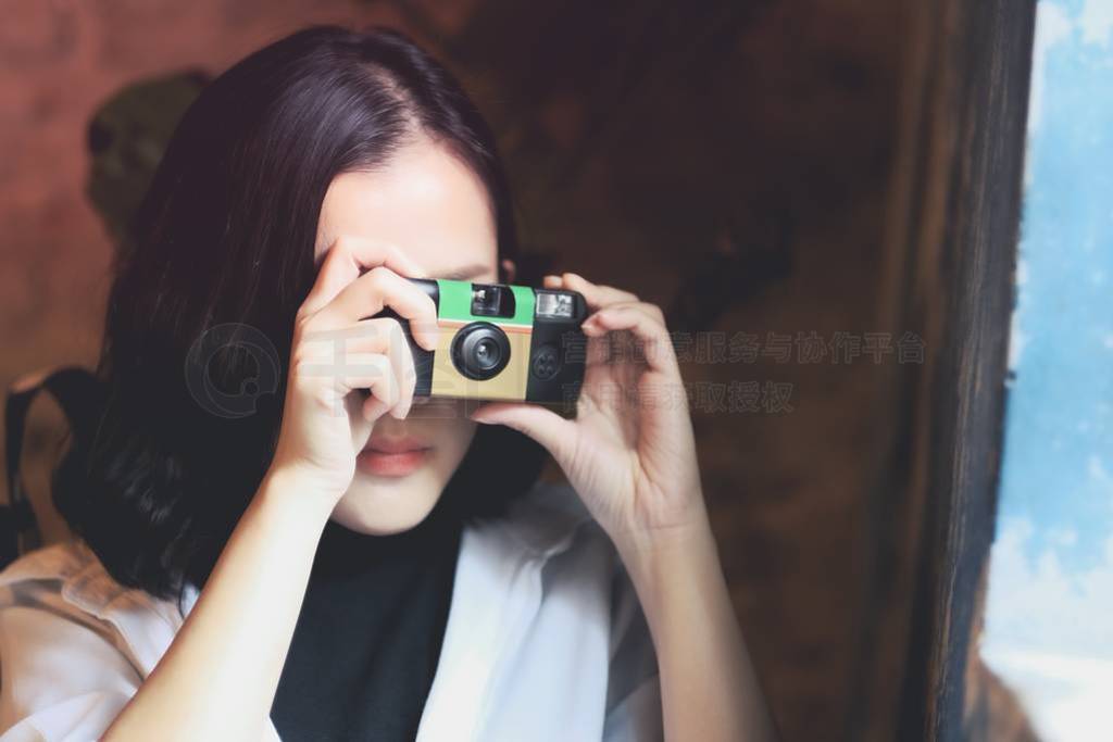 Asian women take a picture by film camera in coffee cafe