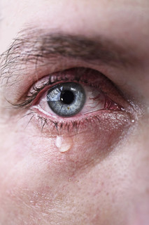 蓝眼睛的男人在悲哀而又充满的坳陷痛苦的眼泪哭的特写