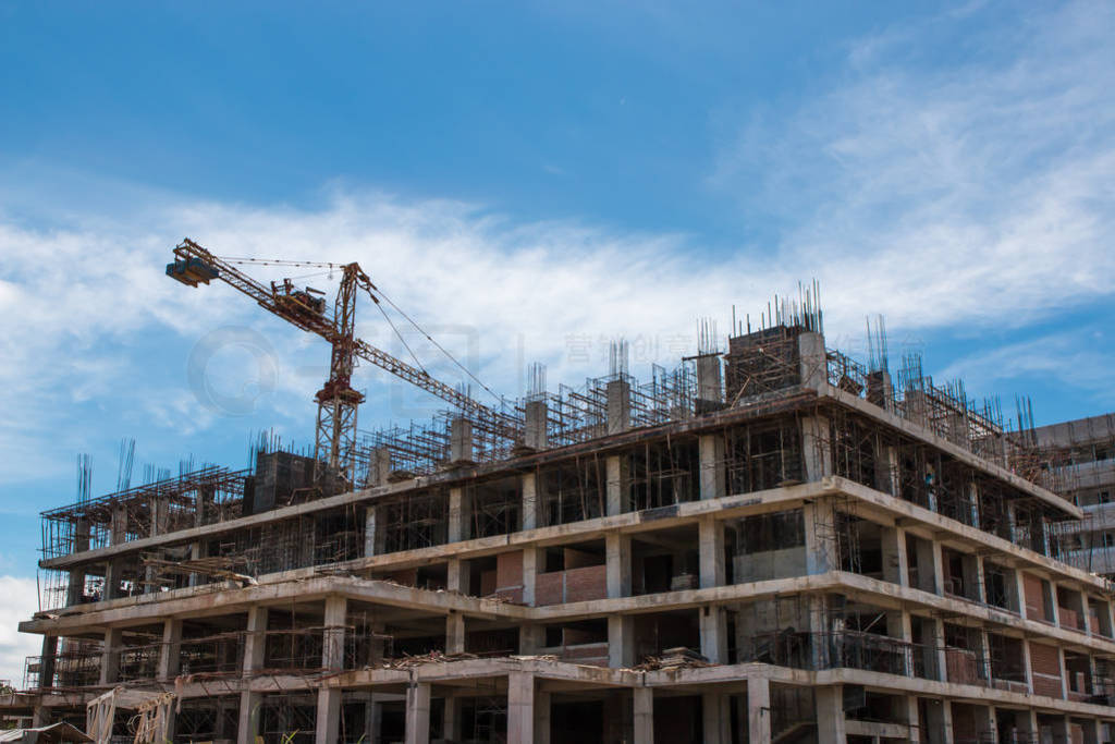 building and crane under construction against blue sky