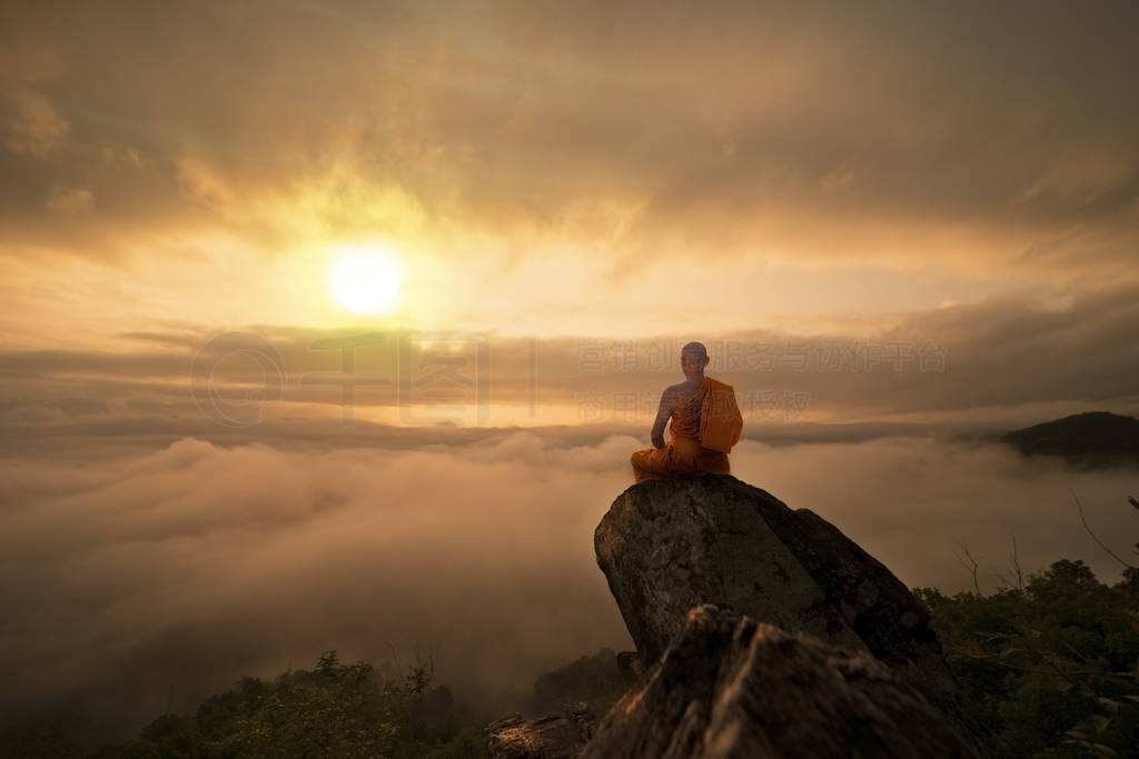 Buddhist monk in meditation at beautiful sunset or sunrise