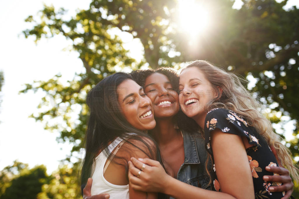 Portrait of a happy multiethnic group female friends hugging and