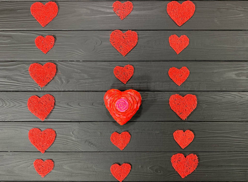 Red hearts laid out in a row on a black background.