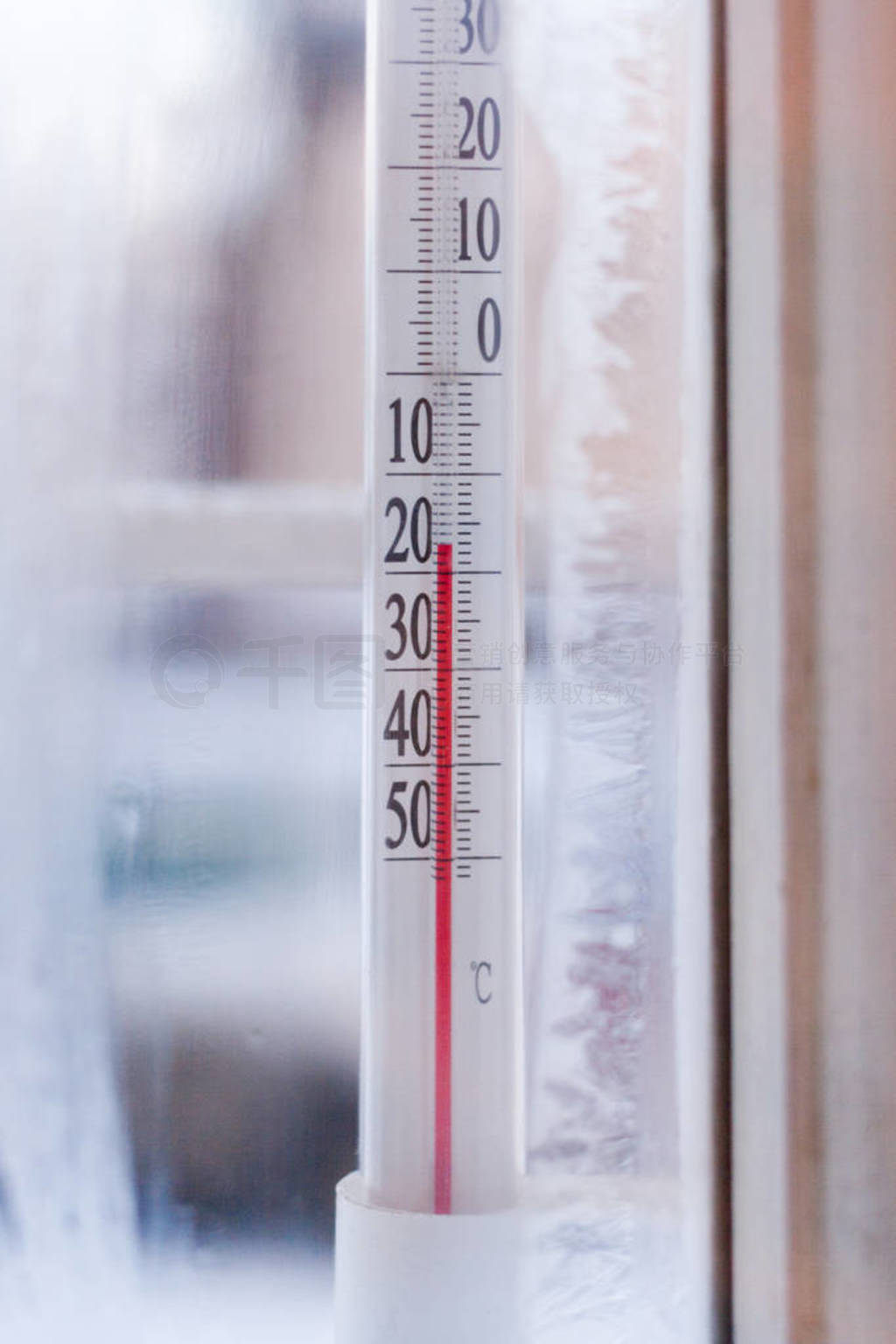 The view through frozen window to the outdoor thermometer which