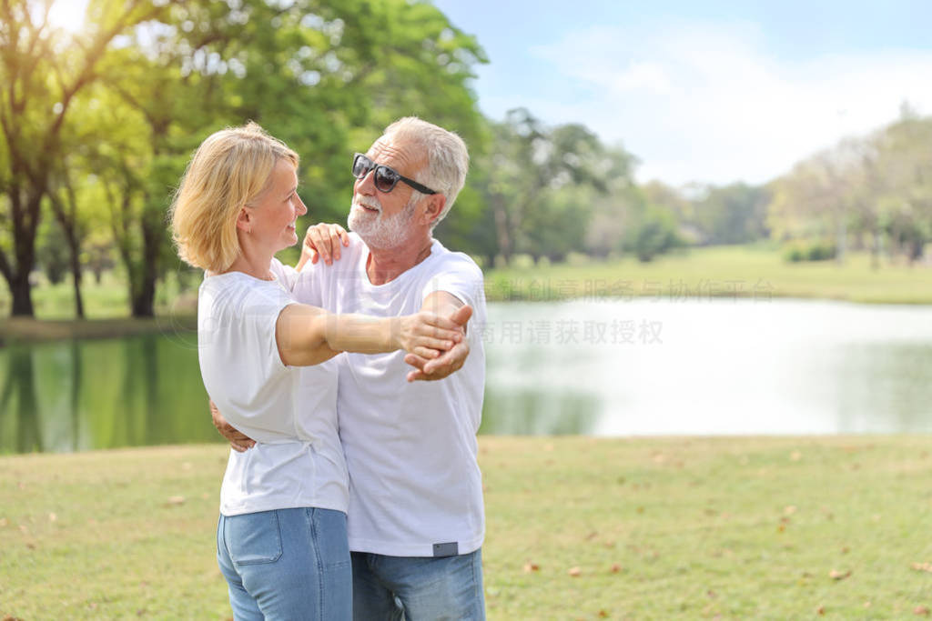 happy elderly couple wearing white shirt and blue jean are danci