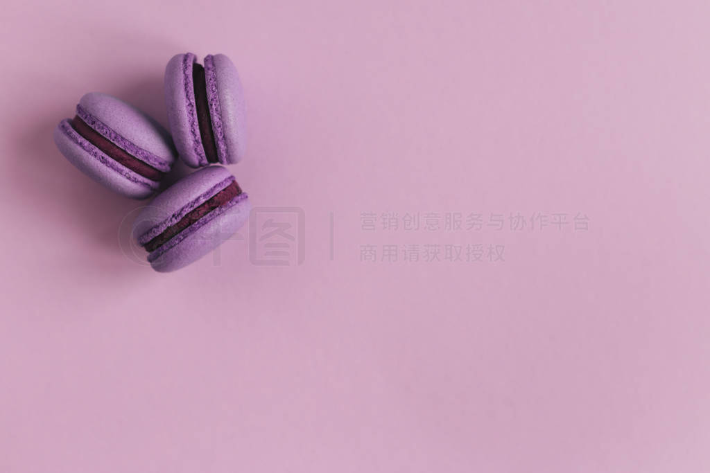 Three french macarons on the purple background. Place for text.