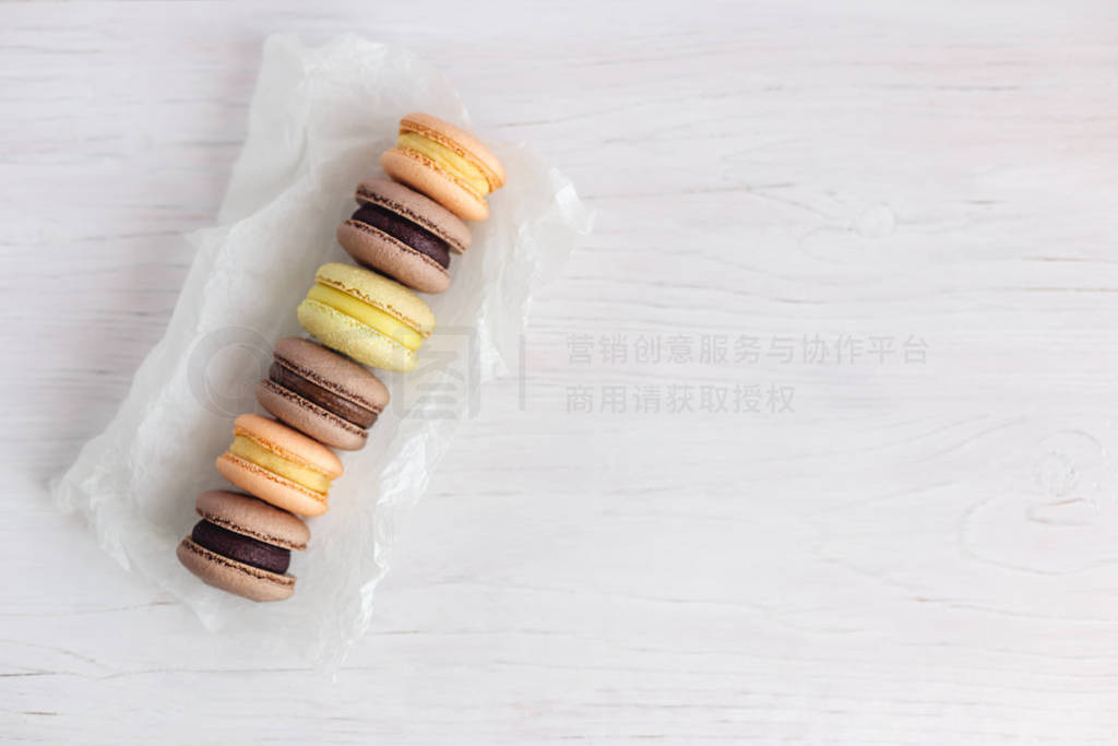 Set of French macarons on a white wooden table. Multicolored mac